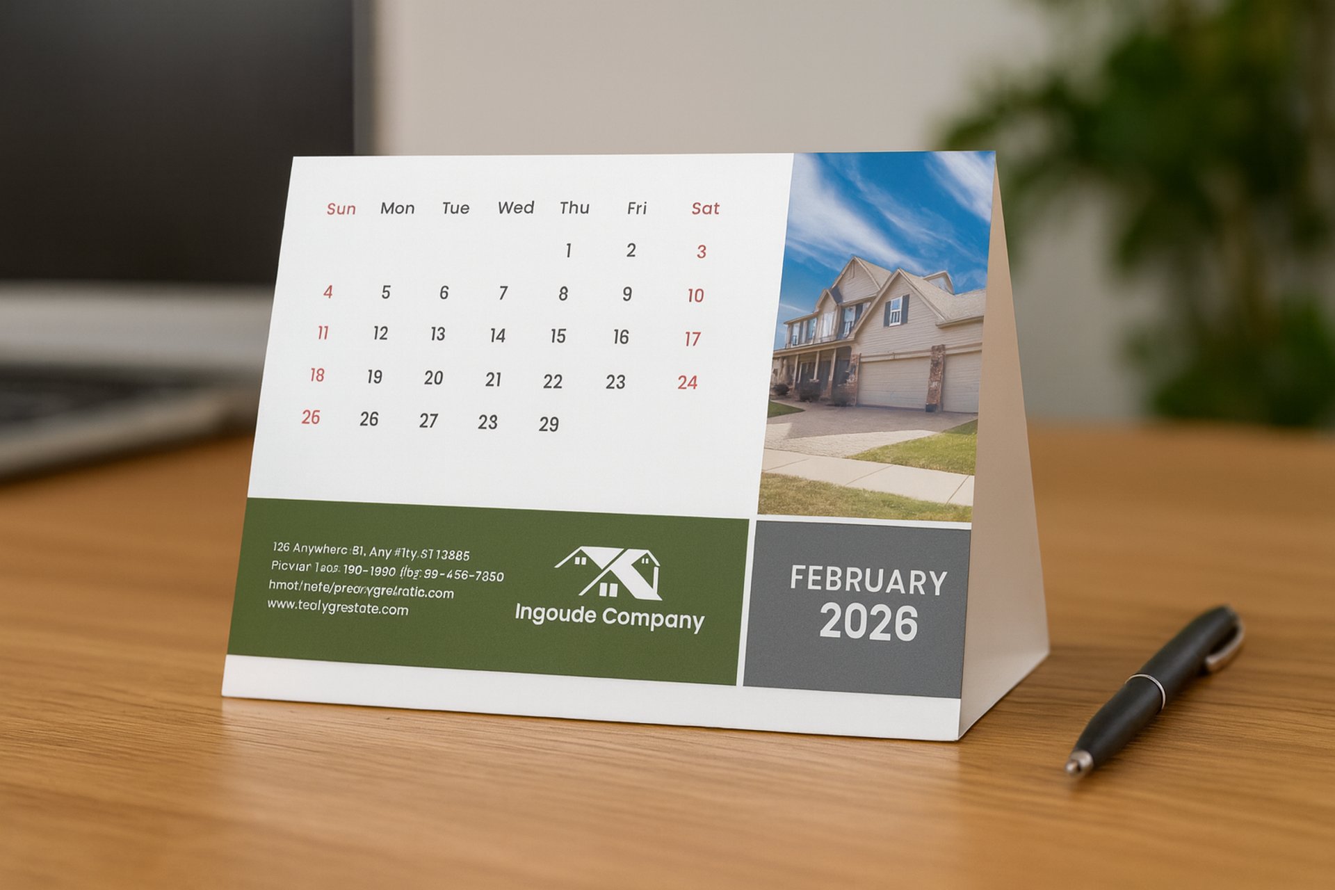 Branded desktop calendar for February 2026 featuring a modern real estate design on an office desk.